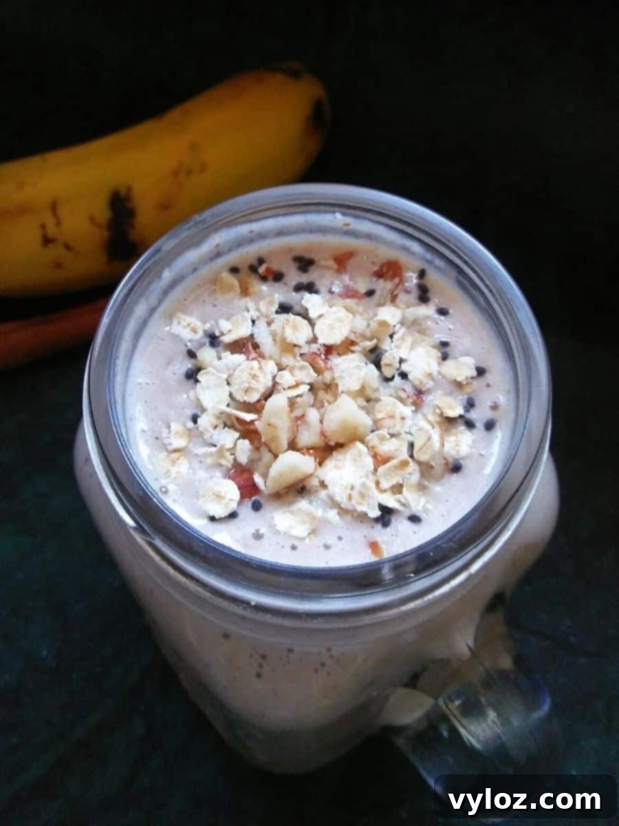 Finished Oats Banana Breakfast Smoothie in a glass with toppings
