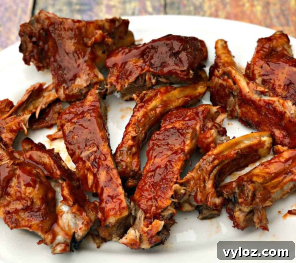 instant pot baby back ribs on a white plate, garnished with fresh herbs