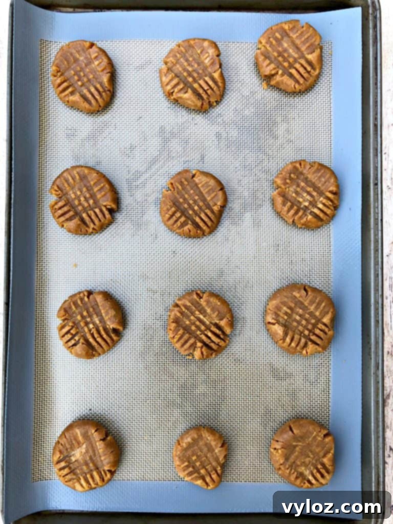 Simple Keto Peanut Butter Cookies 6 raw cookie dough balls on a cookie sheet