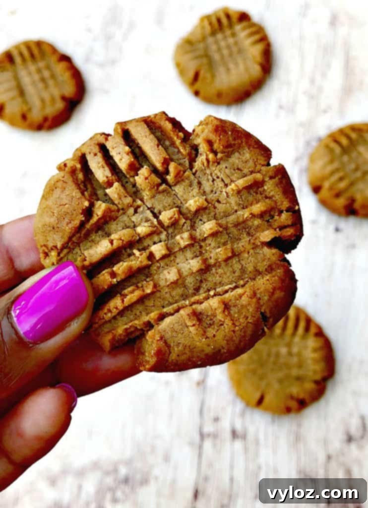 Simple Keto Peanut Butter Cookies 8 person holding keto peanut butter cookies