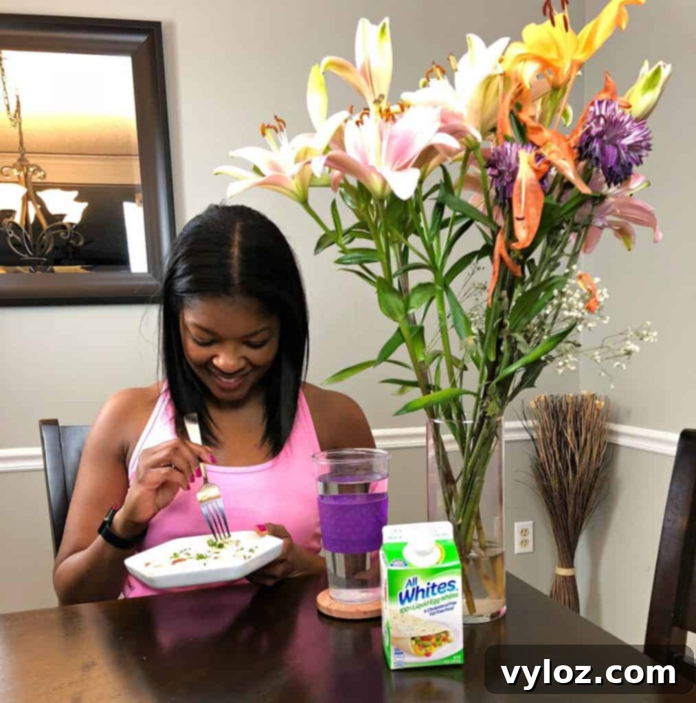 Keto Veggie Egg White Bites 10 A woman enjoys a healthy egg frittata at a dining table, illustrating a satisfying breakfast meal.
