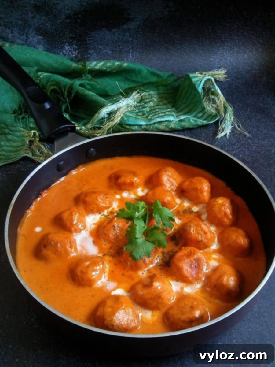 Velvety Indian Butter Chicken Meatballs 2 Chicken Meatballs in rich, vibrant Butter Sauce, garnished with fresh cilantro.