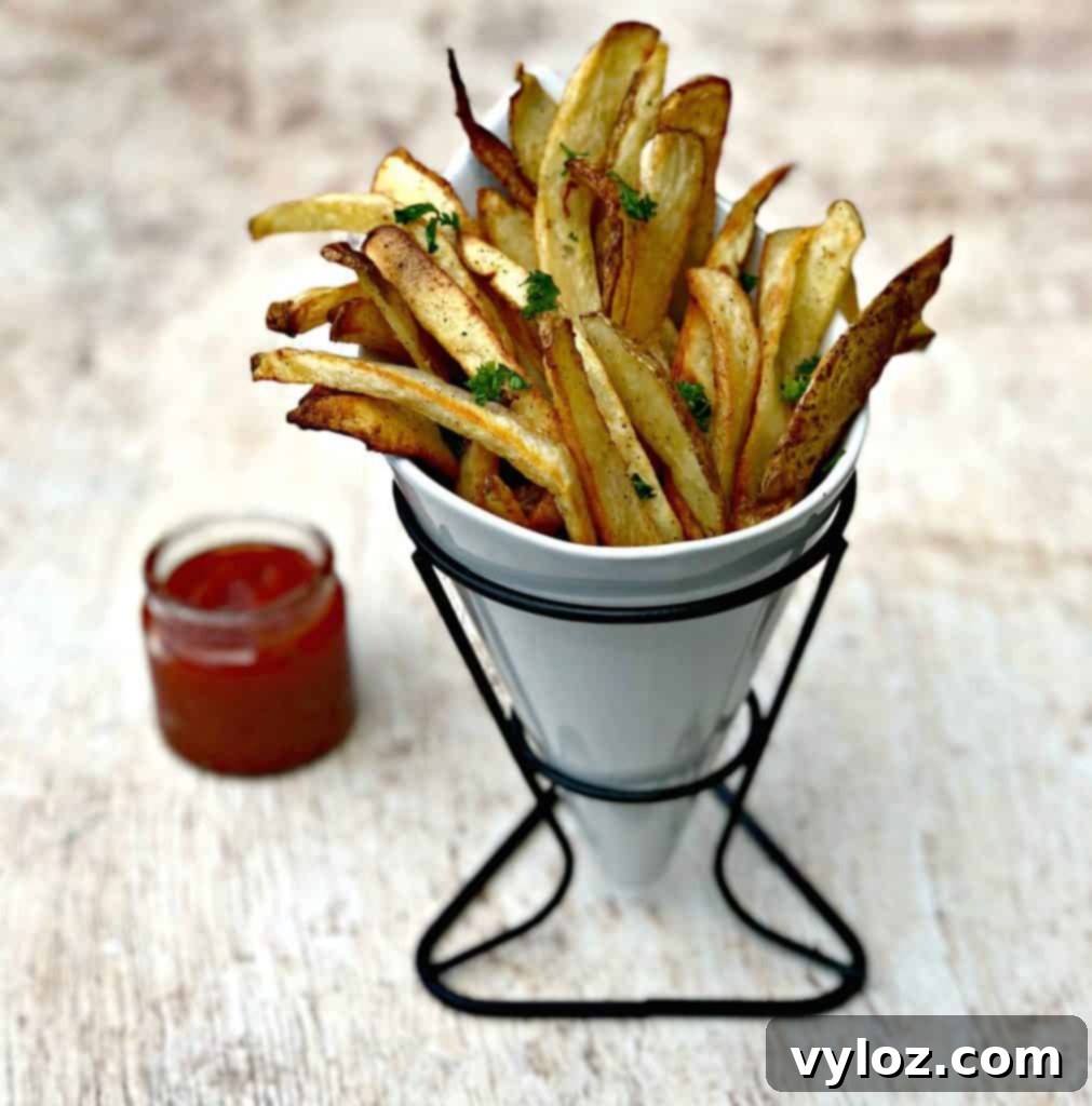 air fryer fries spread out on a brown surface with ketchup