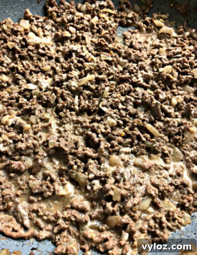 Keto Cheeseburger Bake 6 Top-down view of a keto cheeseburger casserole in a ceramic baking dish, freshly baked with melted, bubbly cheese and visible ground beef.