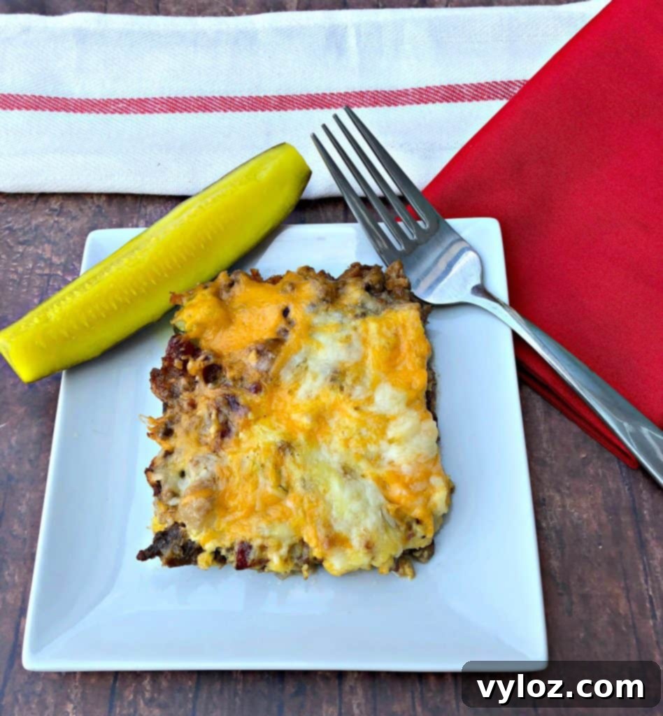 Keto Cheeseburger Bake 9 Close-up of the Keto Low-Carb Cheeseburger Casserole, showing a perfect slice with visible ground beef, melted cheese, bacon, and pickles, ready to be enjoyed.