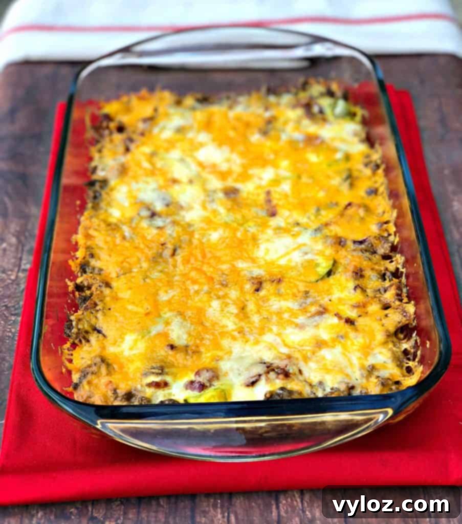 Keto Cheeseburger Bake 10 A generous serving of Keto Cheeseburger Casserole in a baking dish, with a scoop removed, showing the rich, layered texture of beef, cheese, and creamy sauce.