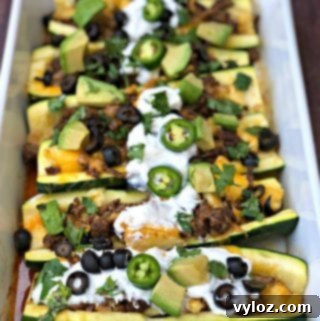 zucchini nachos with olives and sour cream in a baking dish