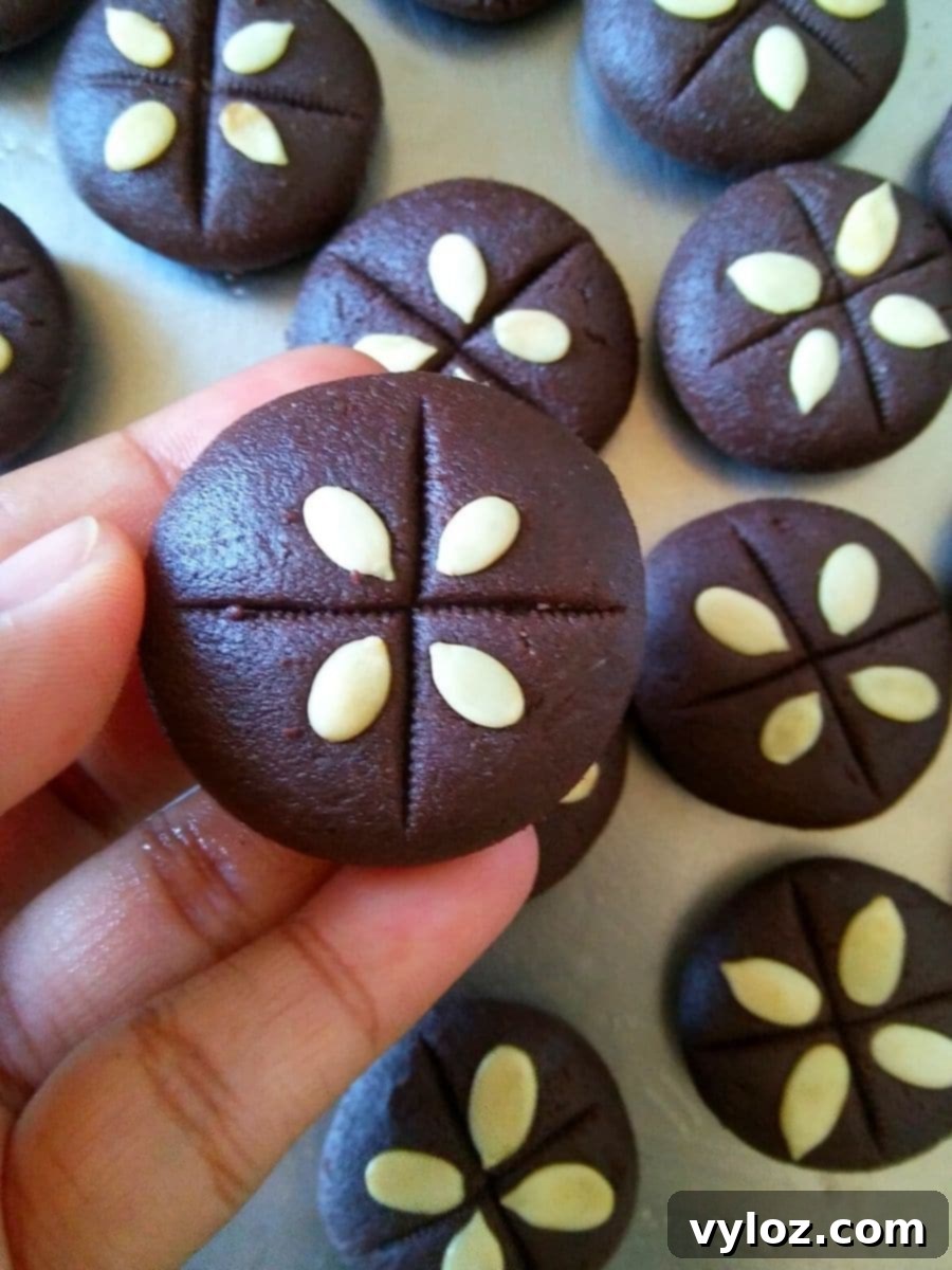 Decorating freshly made chocolate pedas with white melon seeds