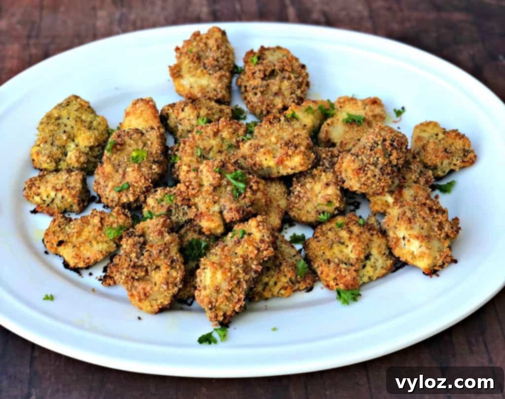 Two cooked keto bacon chicken nuggets on a white plate