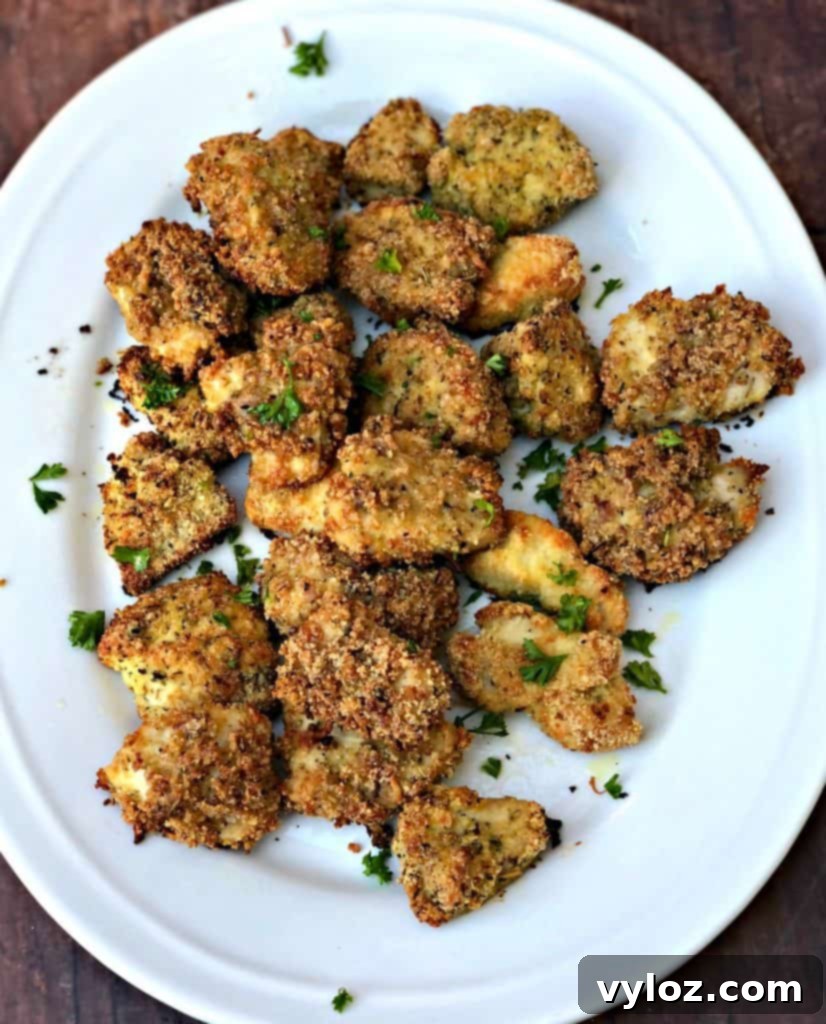 Two cooked keto bacon chicken nuggets with avocado ranch dip