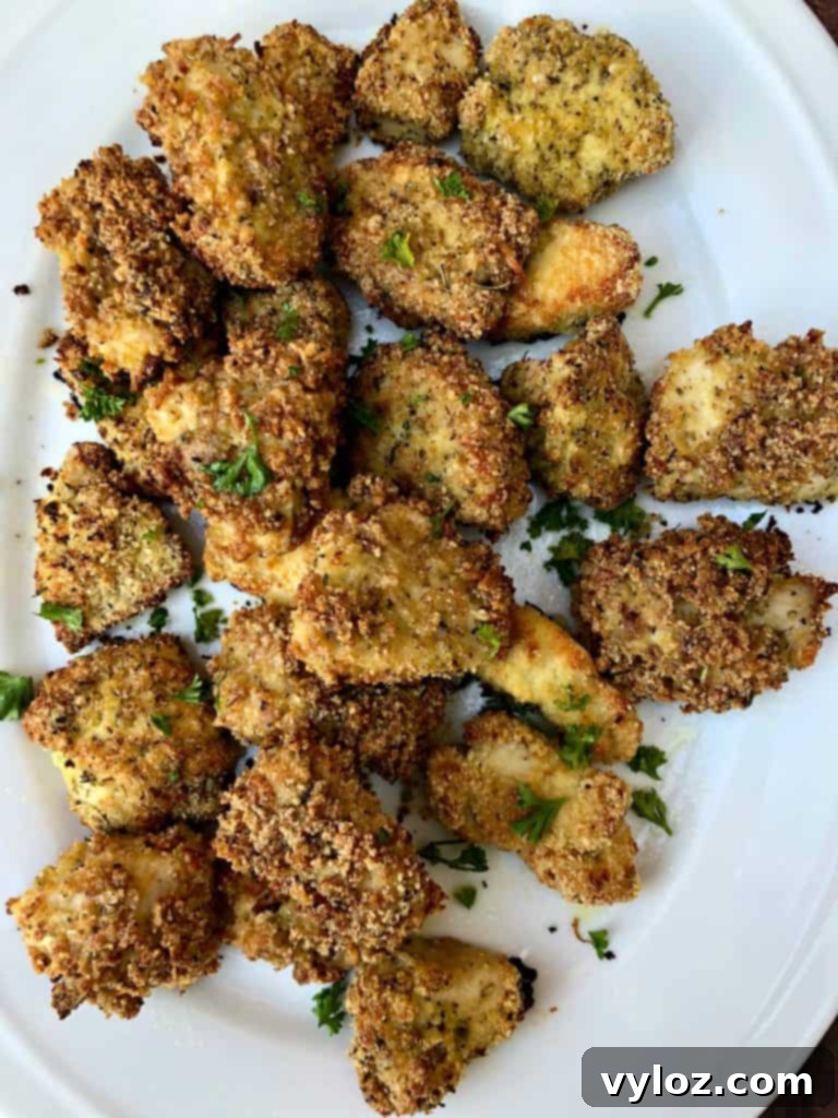 Close-up of two cooked keto bacon chicken nuggets on a white plate