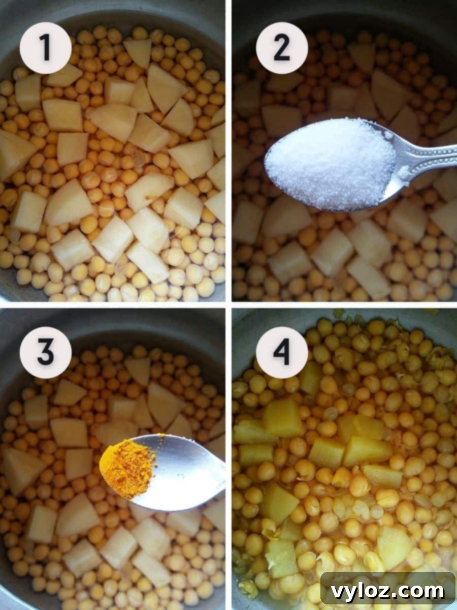 White peas and potato cubes cooking in a pressure cooker with turmeric and salt.