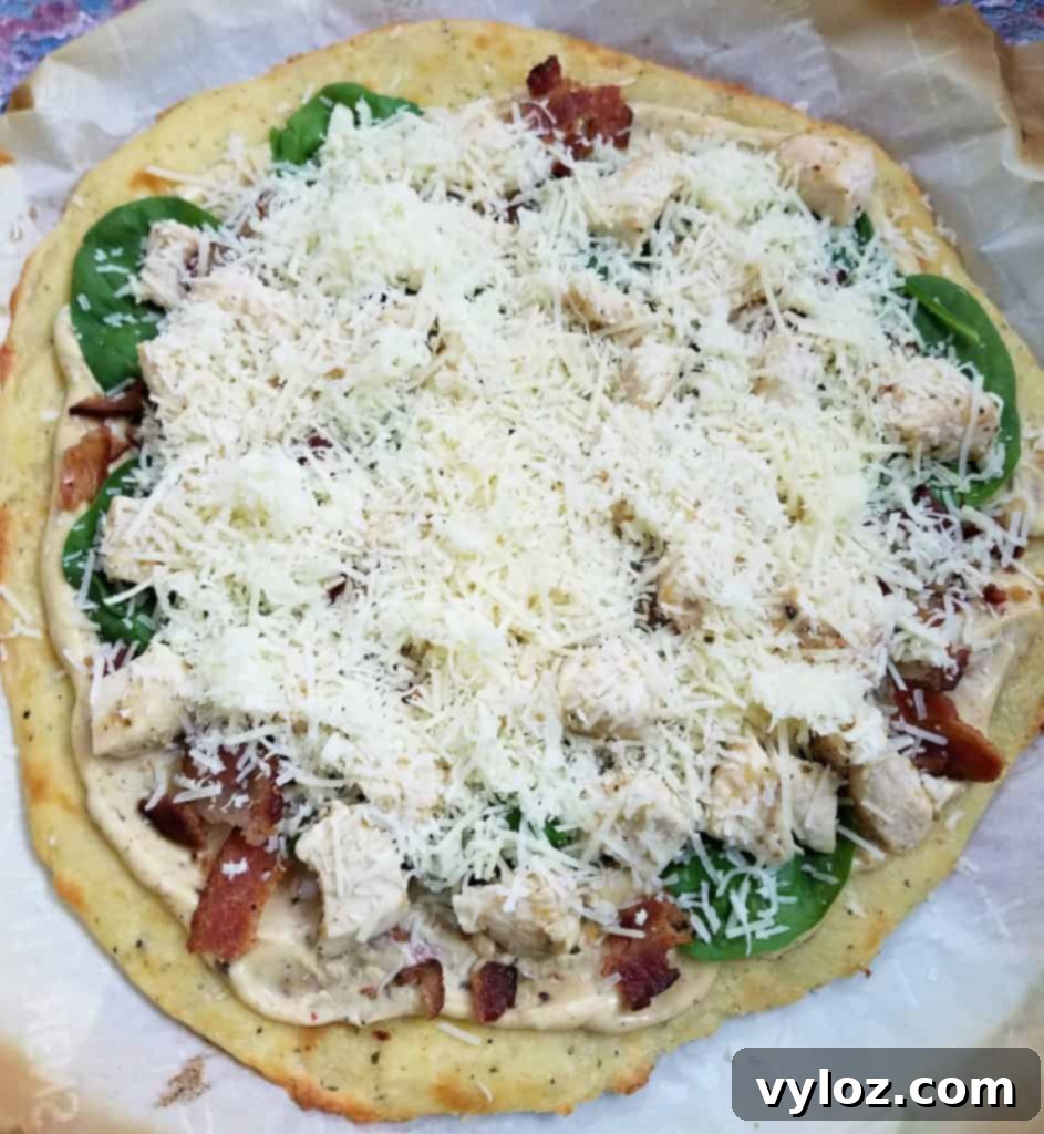 Indulgent Keto Chicken Alfredo Pizza 3 uncooked pizza with shredded cheese