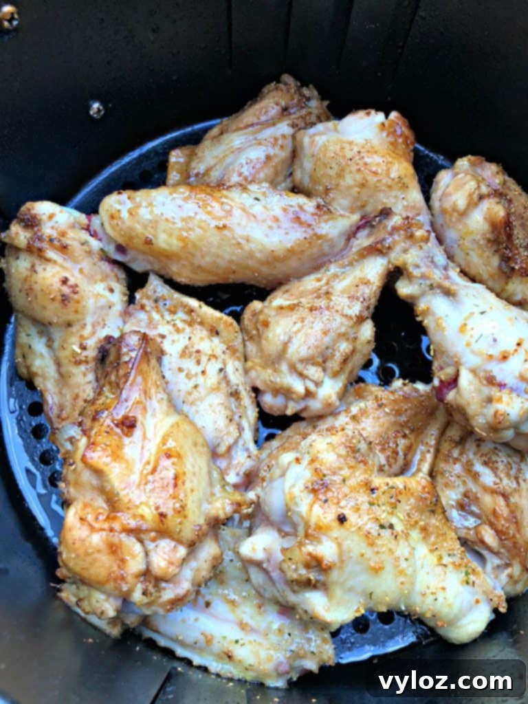 Ultimate Air Fryer Buffalo Wings 5 Perfectly cooked and crispy chicken wings in an air fryer basket