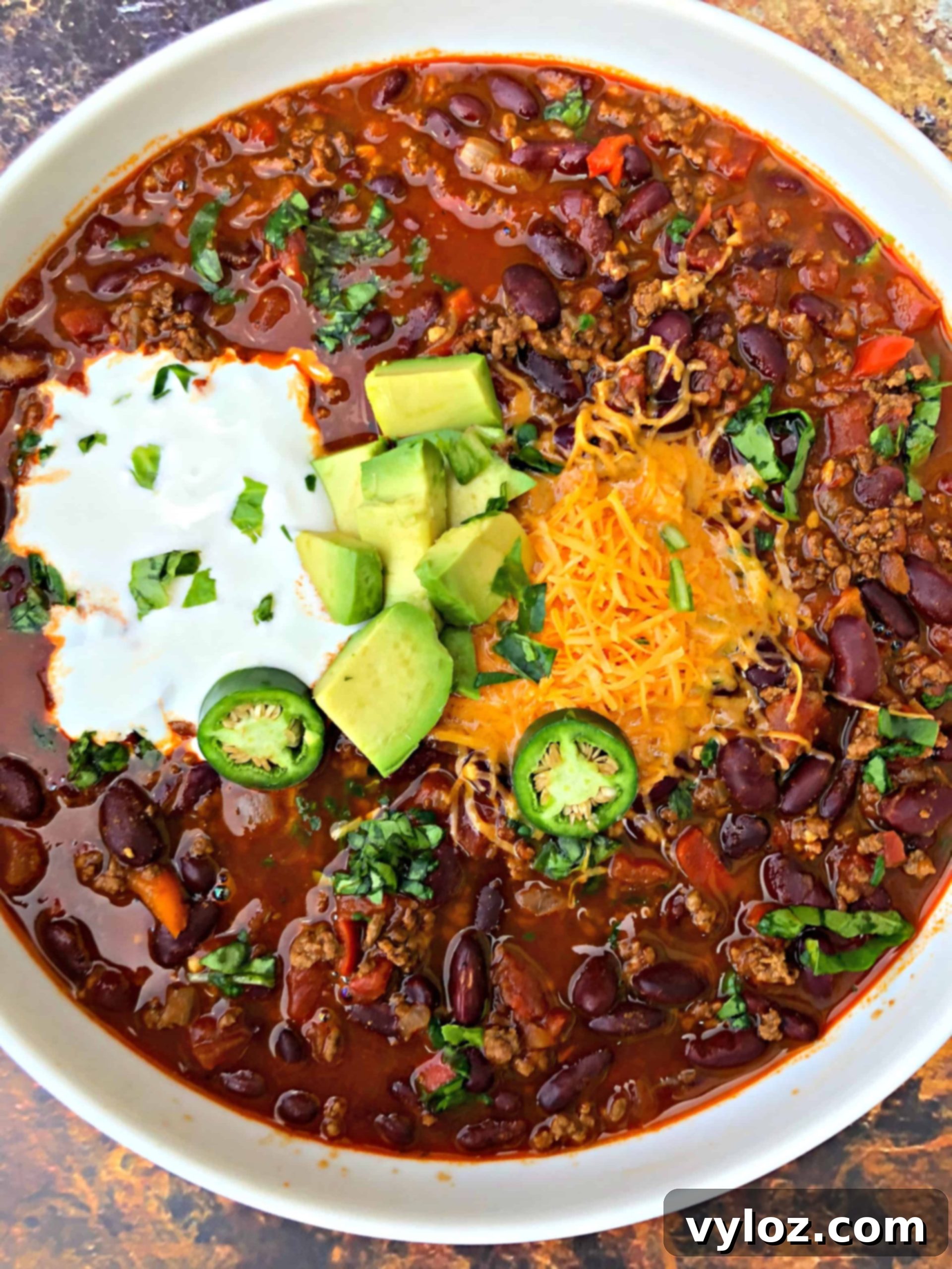 A steaming bowl of Instant Pot beef chili, garnished with fresh herbs and a swirl of sour cream, ready to be enjoyed.