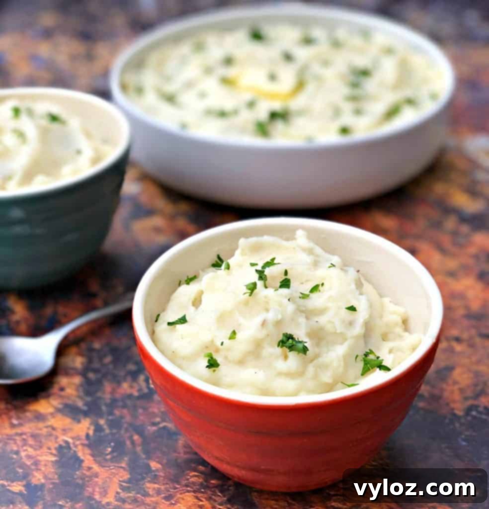 Instant Pot garlic mashed potatoes piled high in three individual serving bowls, ready for a meal.