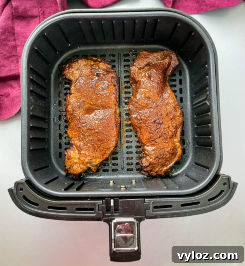 Perfectly cooked, juicy air fryer steak in the air fryer basket, ready to be served.