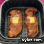 Perfectly cooked, juicy air fryer steaks topped with melting butter and fresh herbs.