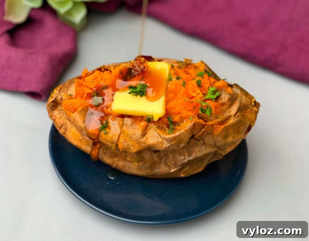 air fryer sweet potato with butter drizzled with honey on a blue plate