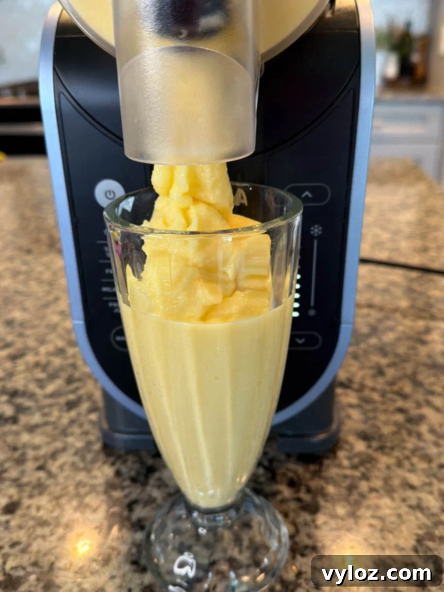 Thick, creamy orange Julius slushie dispensing from the Ninja Slushi machine